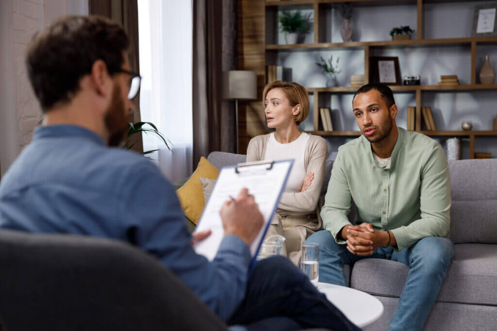 Multiracial quarrel between husband and wife at a session with a psychotherapist. A visit to a family psychologist for a.